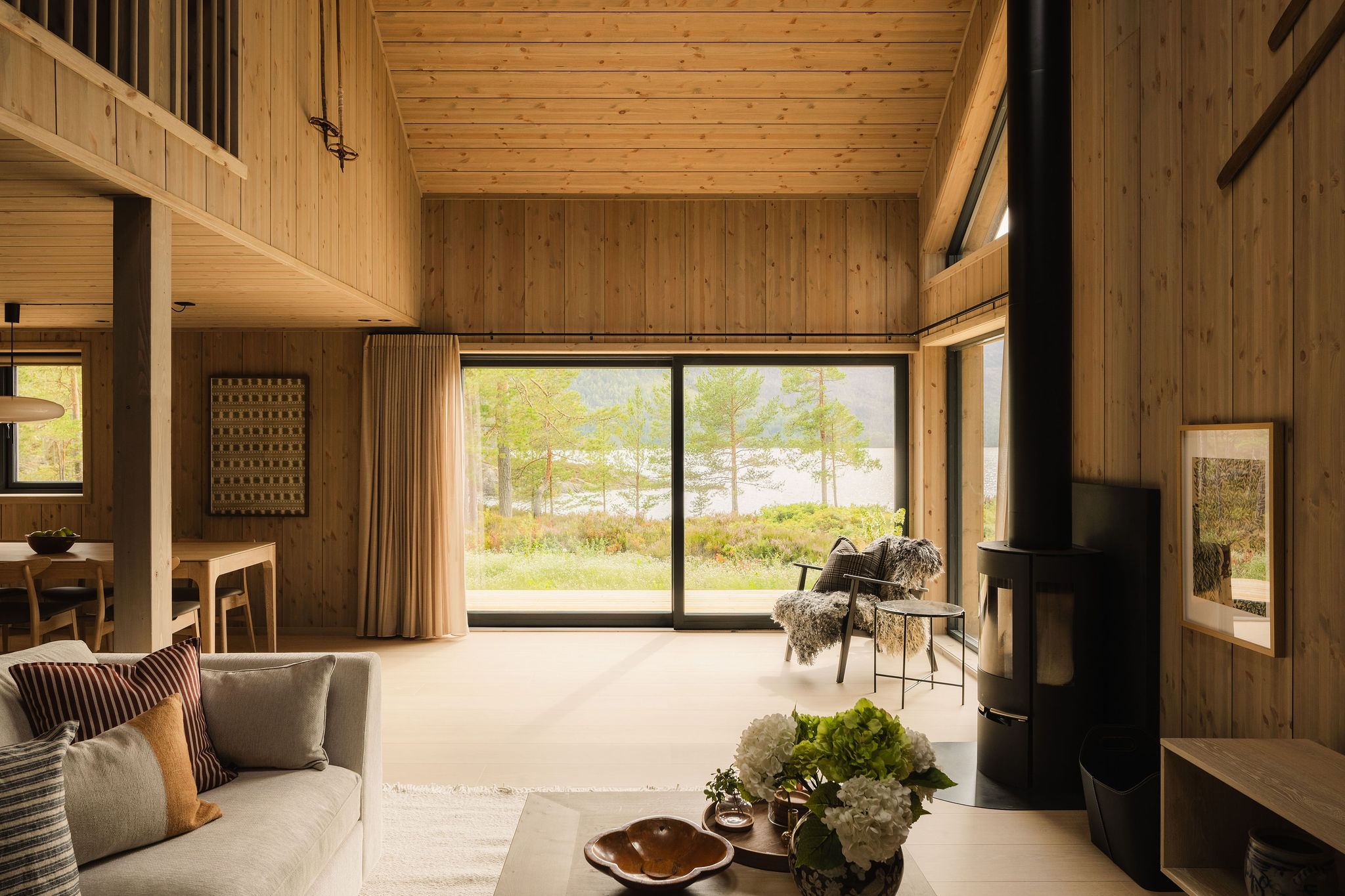 Woonkamer van Lake House Sundsøy met houtkachel, vide en open bovenverdieping