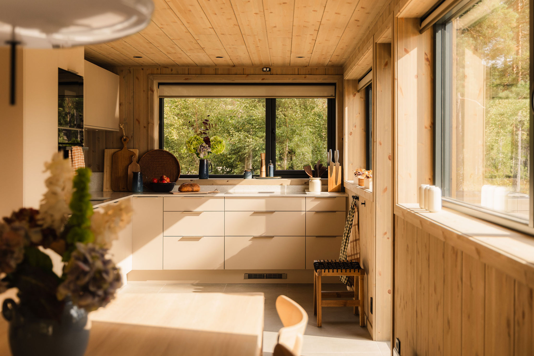 Keuken met raam boven het aanrecht, uitzicht op het bos