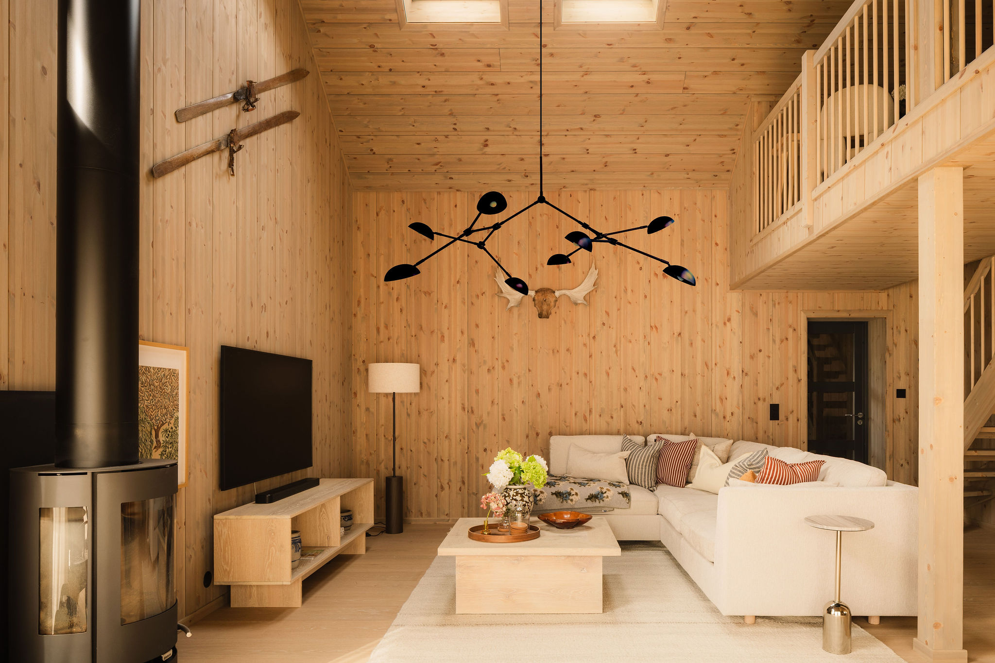 Woonkamer met loungebank, tv en houtkachel