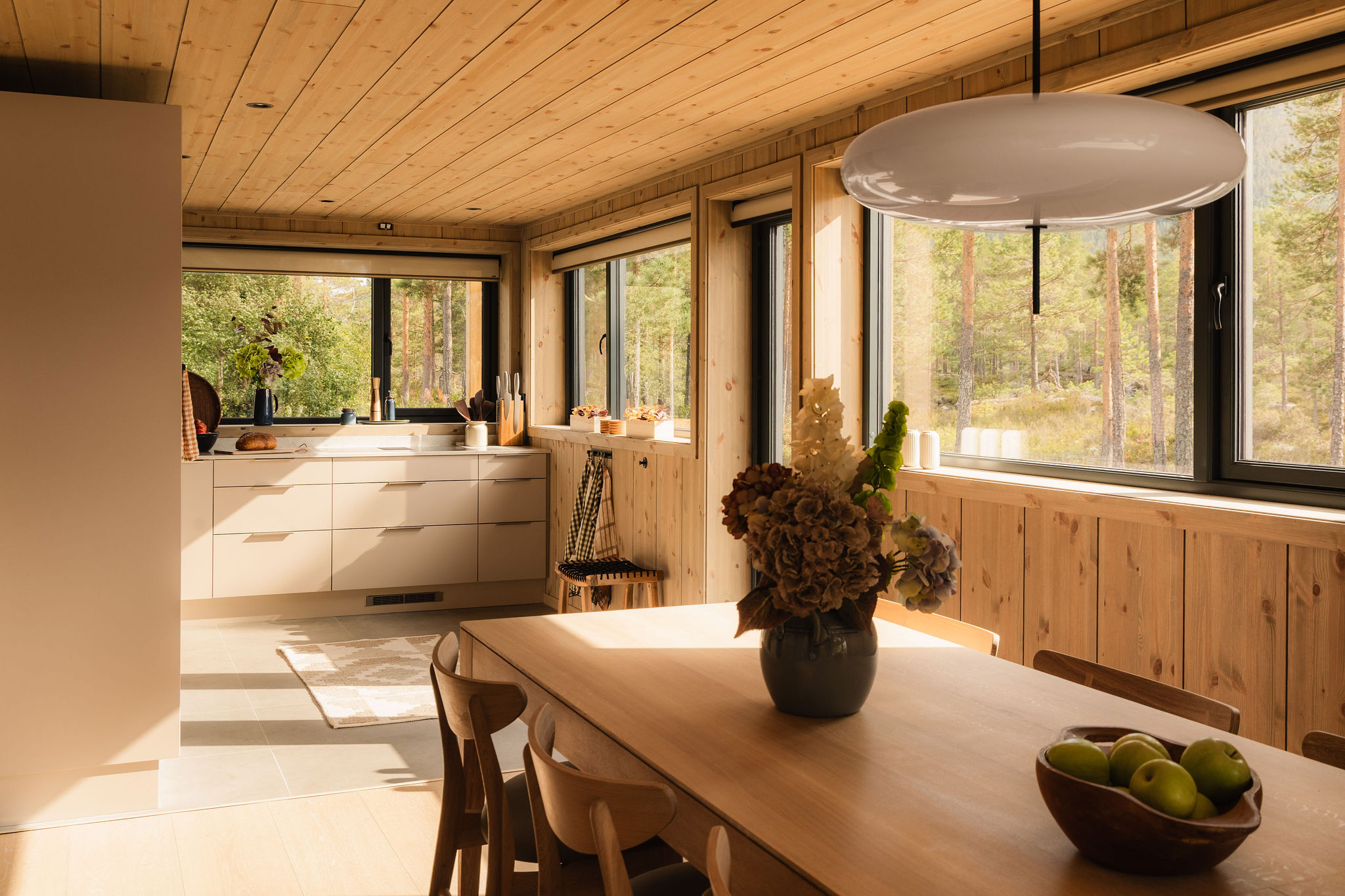Keuken en eettafel met bloemen en fruit, uitzicht op het bos