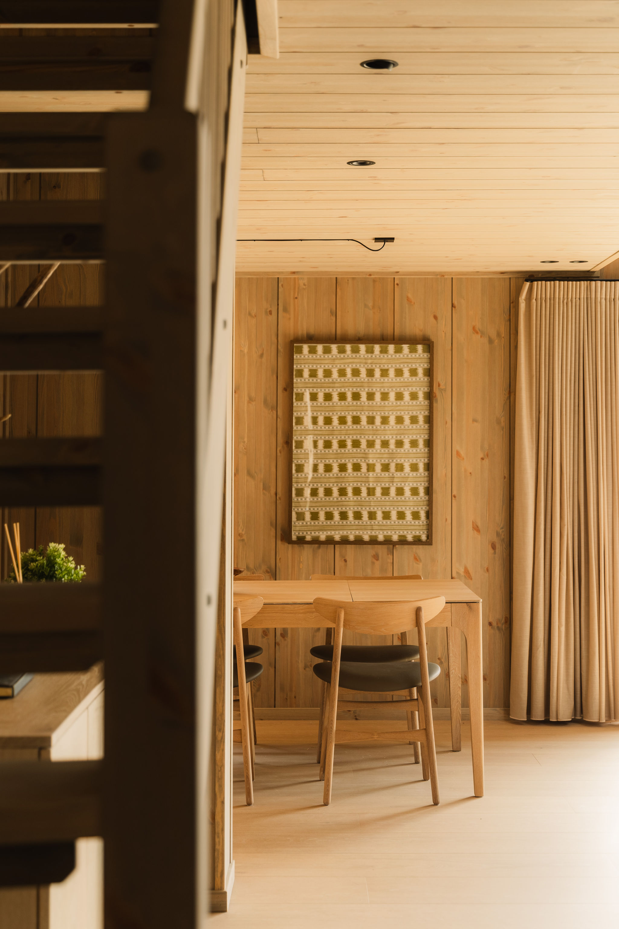 Eettafel gezien vanaf de trap, met houten wanden