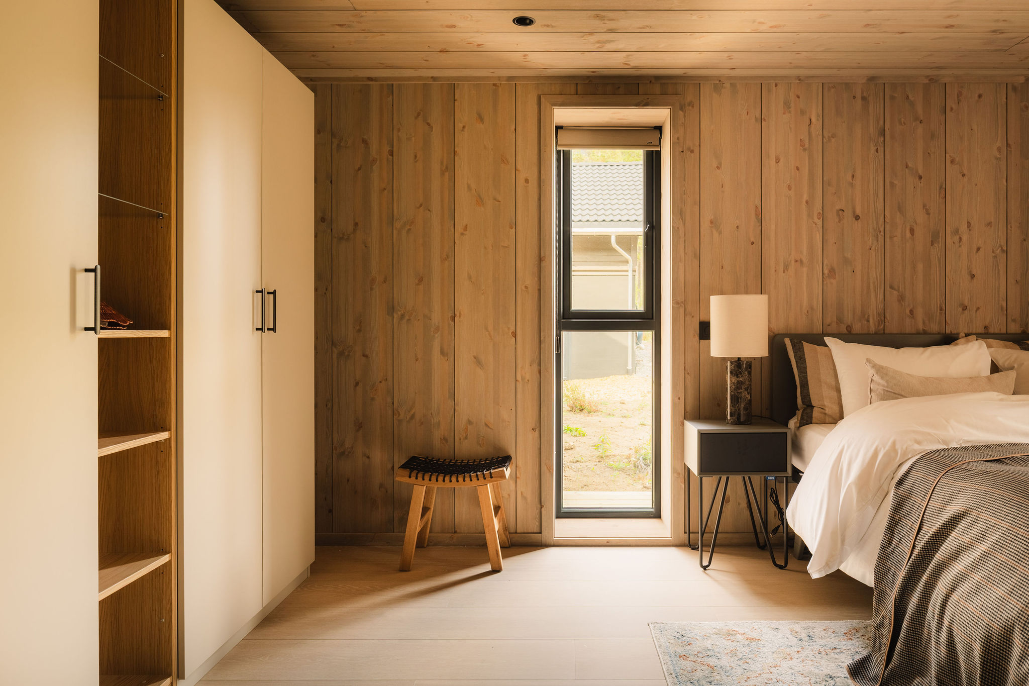 Slaapkamer met inbouwkast en smal raam