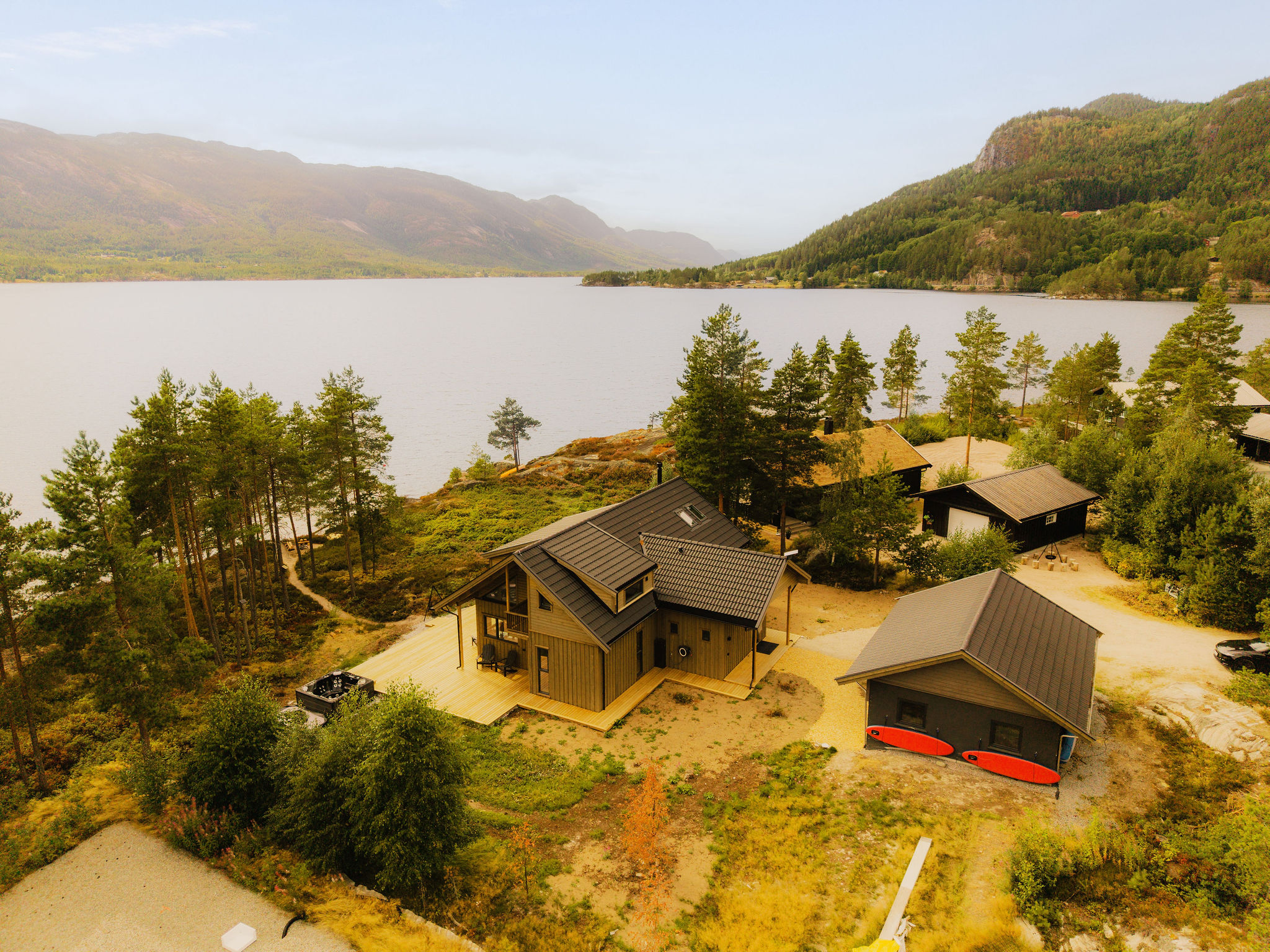 Luchtfoto van het huis met bijgebouwen en het meer op de achtergrond