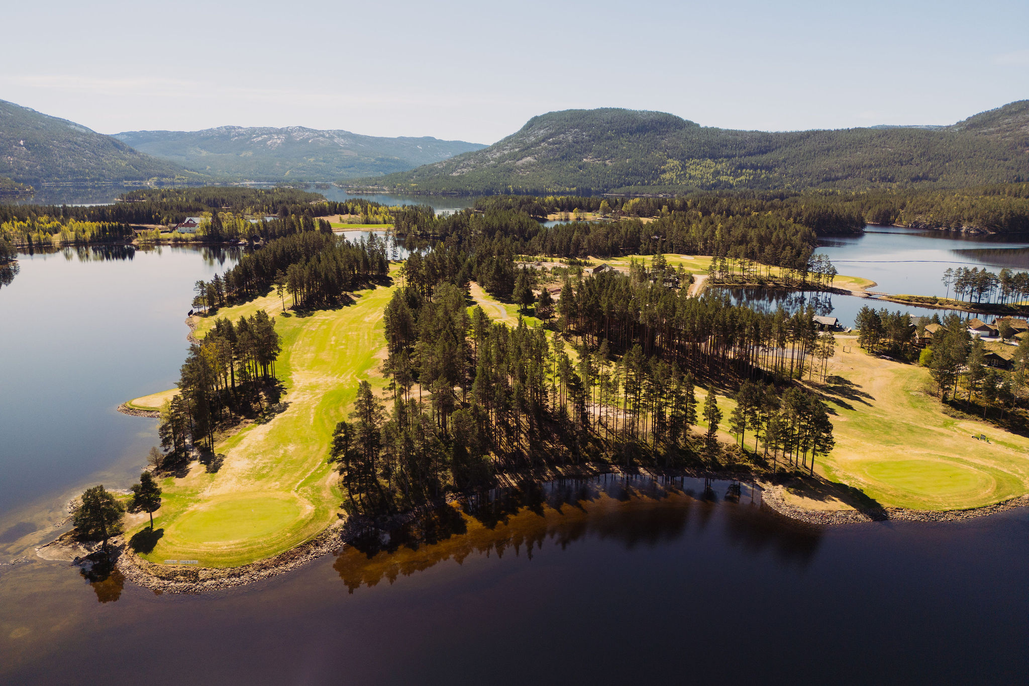 Het meer bij Vrådal met beboste oevers en de bergen van Telemark aan de horizon